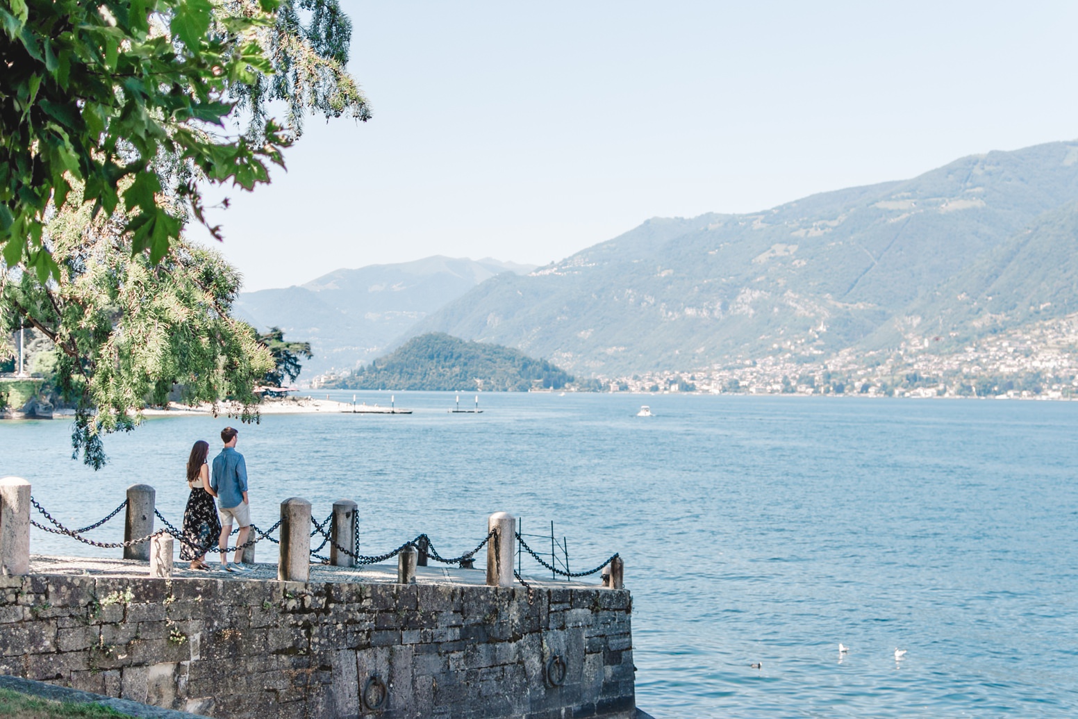 Couple waling on pier in Lake Como