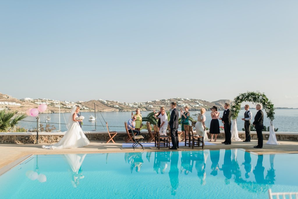 Bride walking down the aisle with swimming pool view
