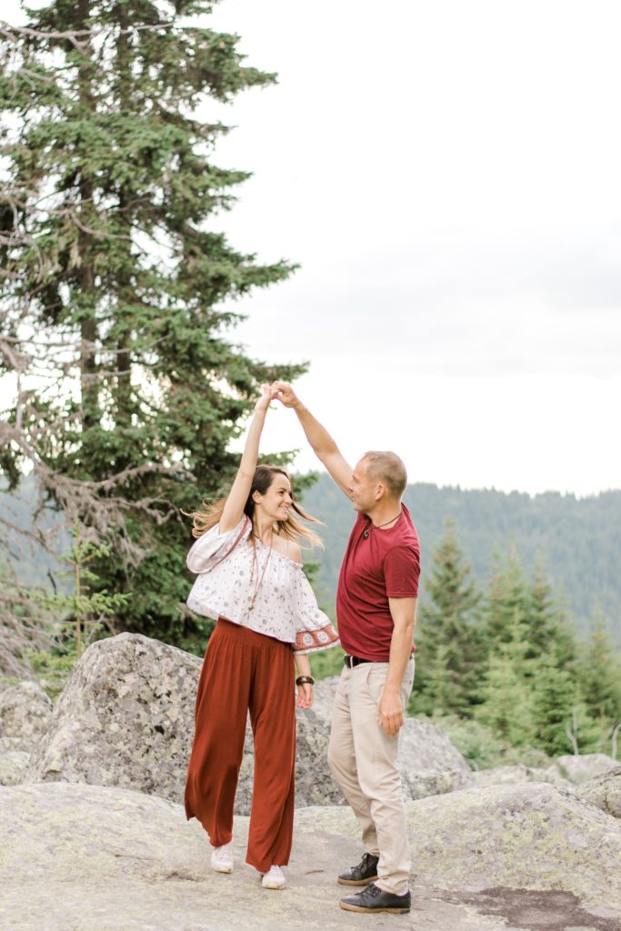 engaged couple dancing in the mountain
