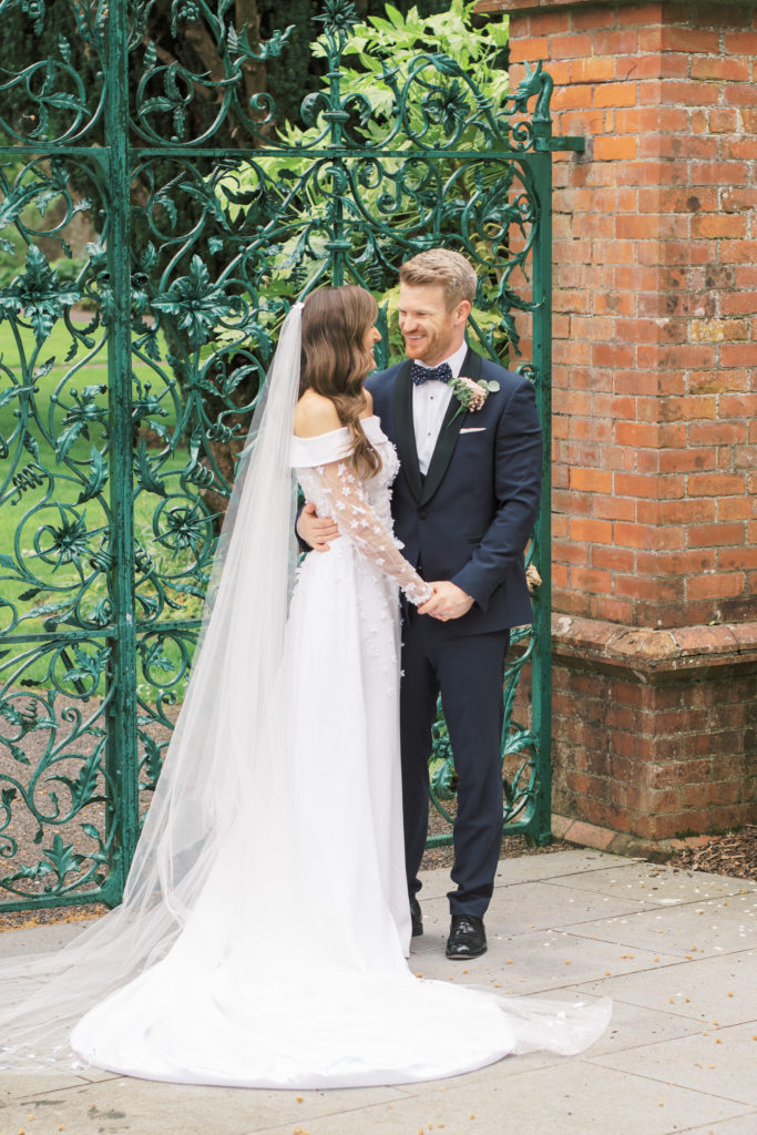 Bride and Groom share a romantic moment in front of the gates of the Walled Garden.