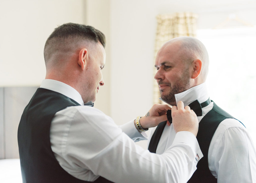 Groom helps his Groomsman prepare for the big day