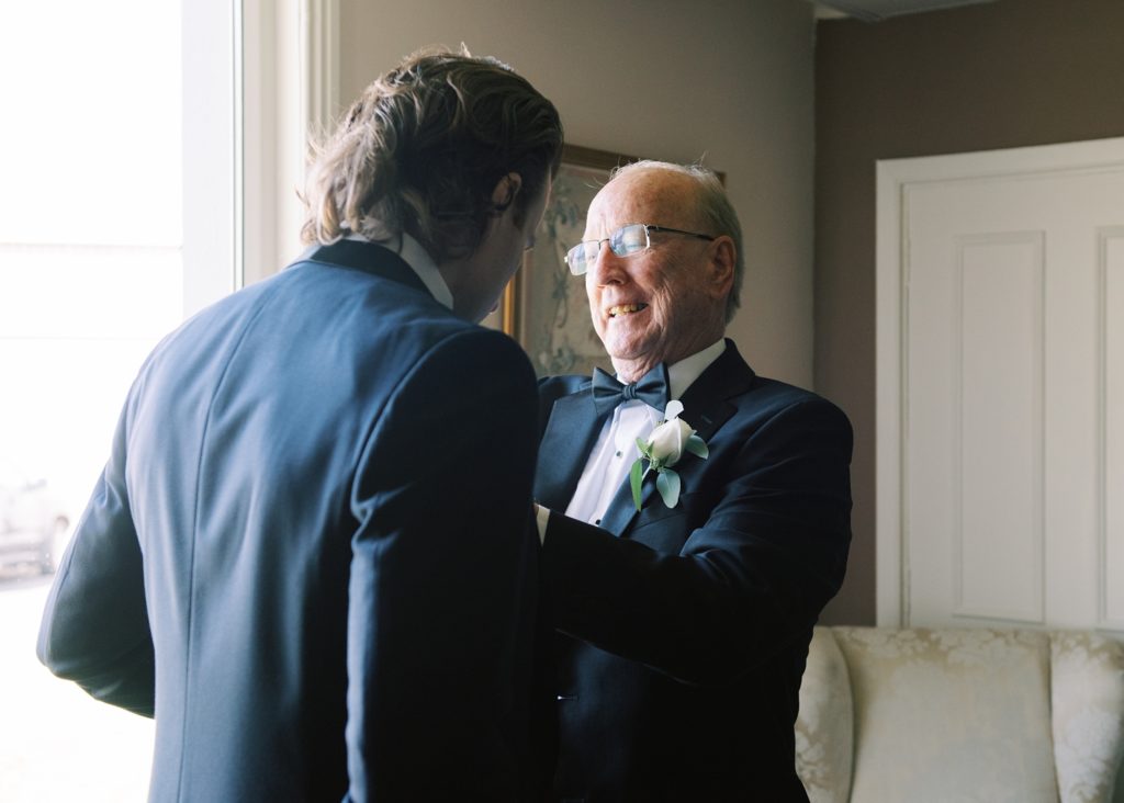 Father helps groom do his tie in the morning before his wedding at Dromoland Castle.