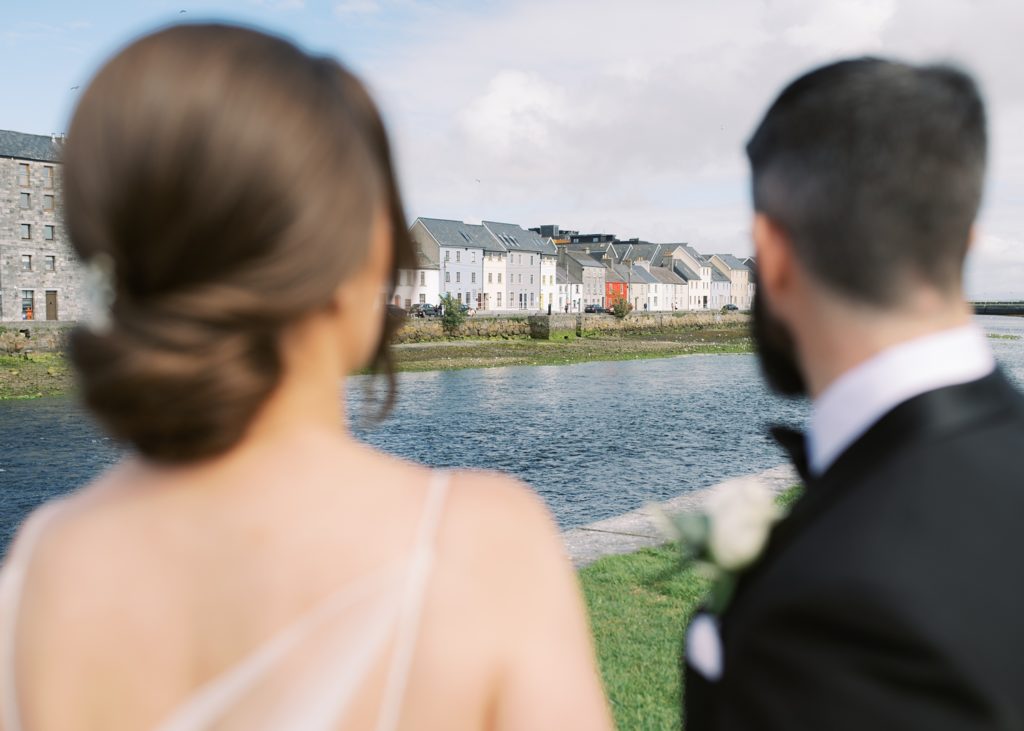 Bride and Groom look out at the Spanish Arch in Galway City.