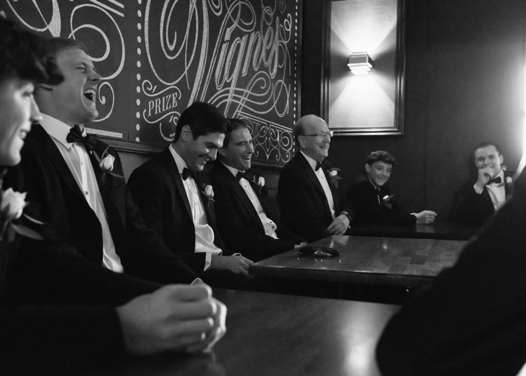Groomsmen and father of groom share laughs together at the bar in The Inn at Dromoland, Ireland.