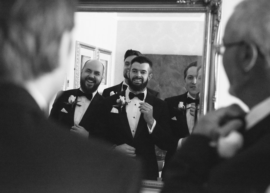 Smiling Groom and groomsmen portrait in mirror together, Galway.