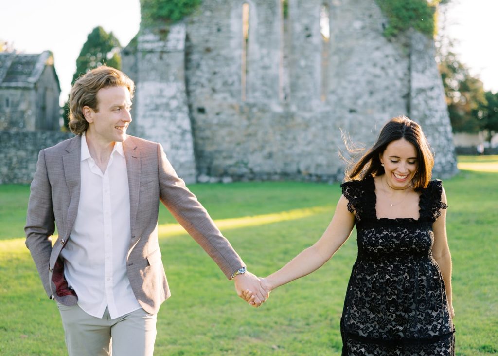 Engagement shoot at Quin Abbey, couple share a laugh together at golden hour.