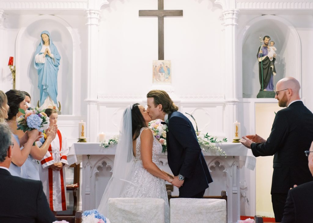 The newlyweds share a kiss at the church alter as their wedding ceremony is concluded.