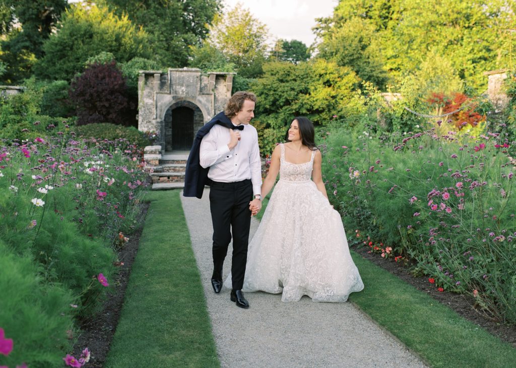 Bride and Groom walk together at sunset in Dromoland Castle's walled garden.