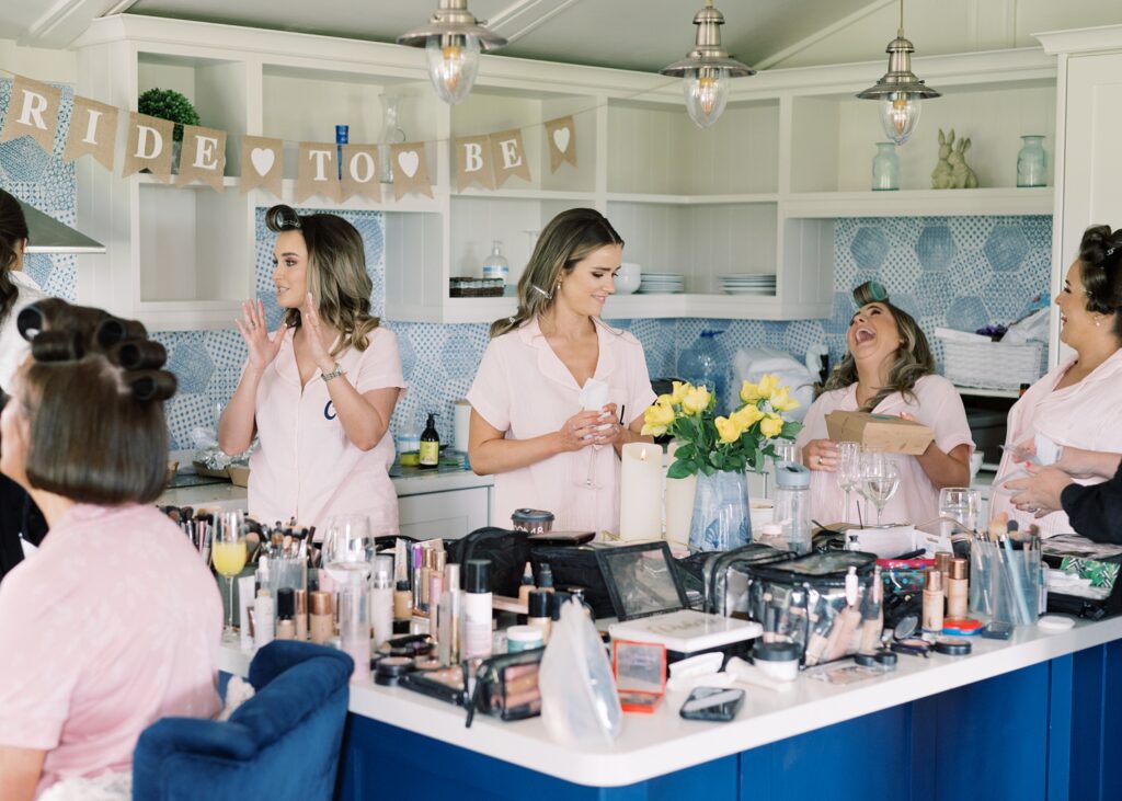 Bride and her bridesmaids enjoying a jovial wedding morning together in their cottage.