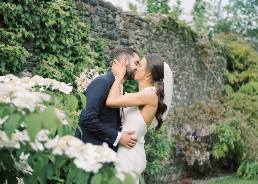 Newlyweds embrace for a kiss on their summer wedding day at Tankardstown House.