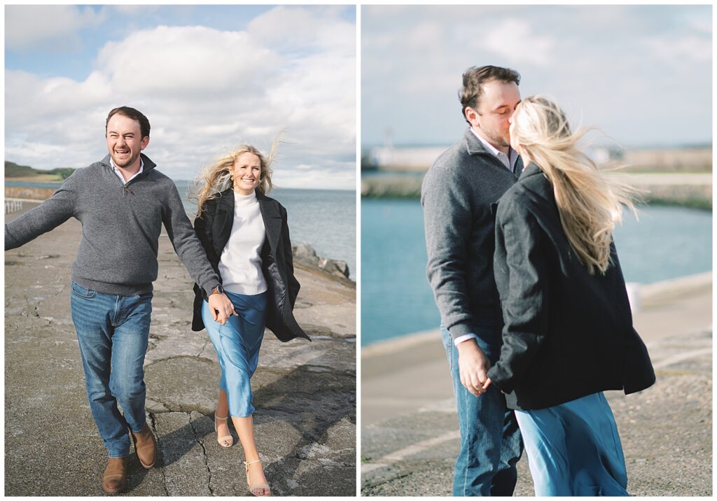 Engaged American couple walking down Howth pier together on a sunny Irish day.
