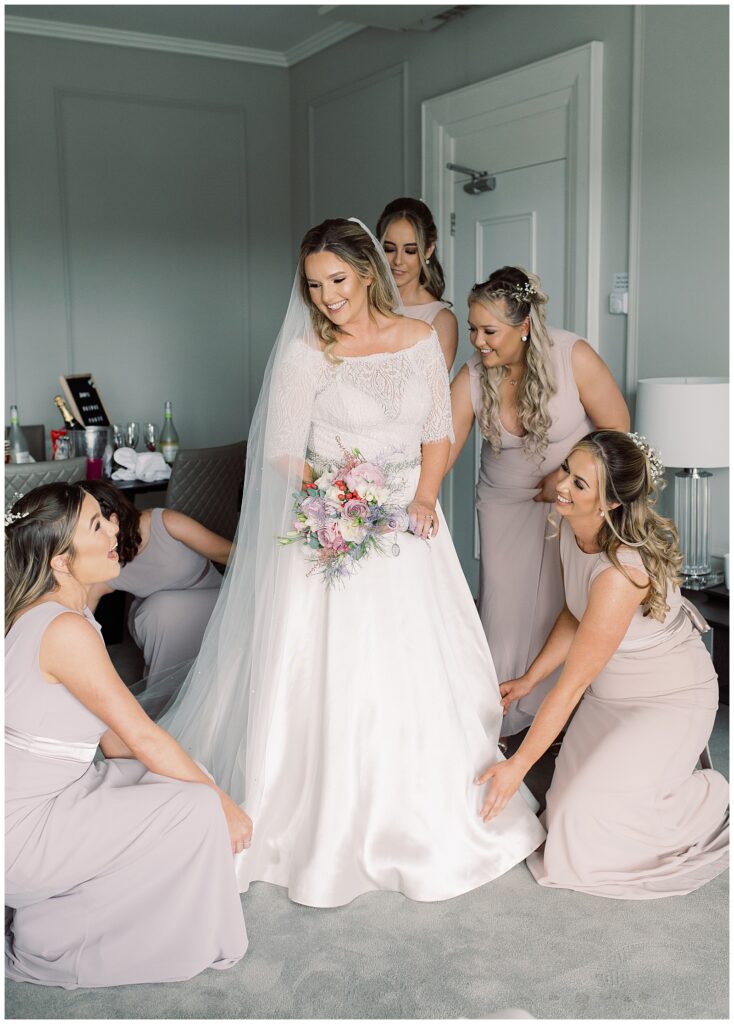 Bridesmaids help prepare the bride in her dress on the morning of her wedding in Ballinasloe, Galway.