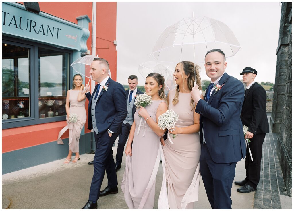Fun outdoor portrait of the wedding party laughing in the rain at Shannonbridge.