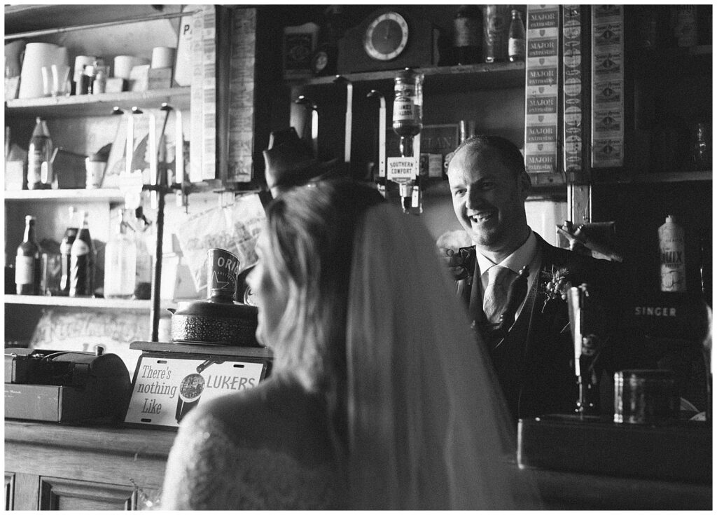 Black and white photo of Bride and Groom enjoying the old fashioned Irish pub together.