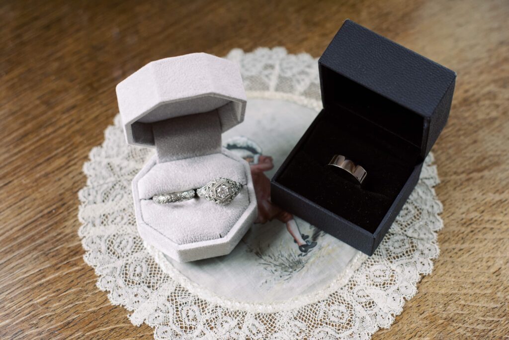Detail photo of the Bride and Groom's ring boxes, placed on a decorative doily in Temple House.