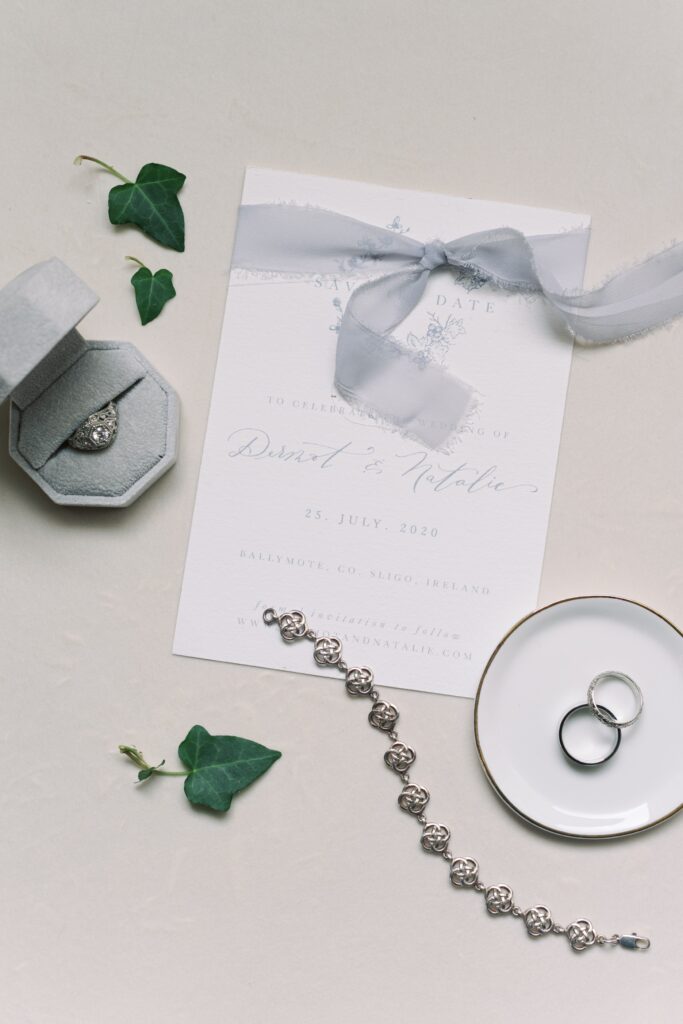 Elegant detail photo of the bride's own invitations, rings, and ivy leaves from Temple House, Ireland.