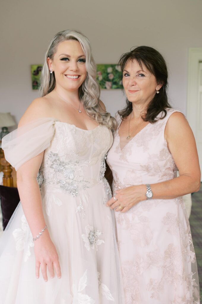Bride and her proud mother pose together for a portrait in the bright front room of Temple House.