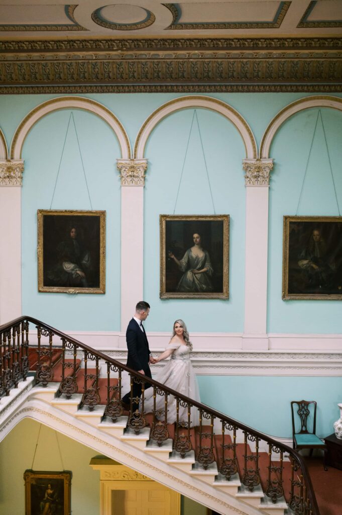 Bride and groom descent the stairs in Temple House for their portraits.