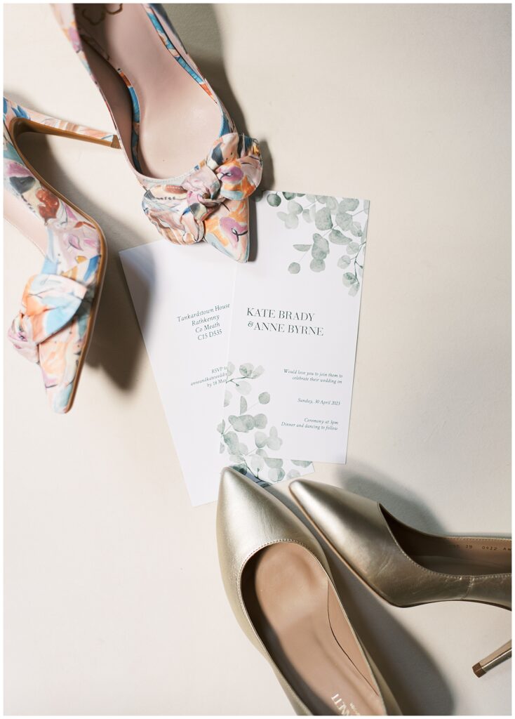 Two pairs of shoes placed beside the invitations to the brides' same-sex wedding at Tankardstown House.