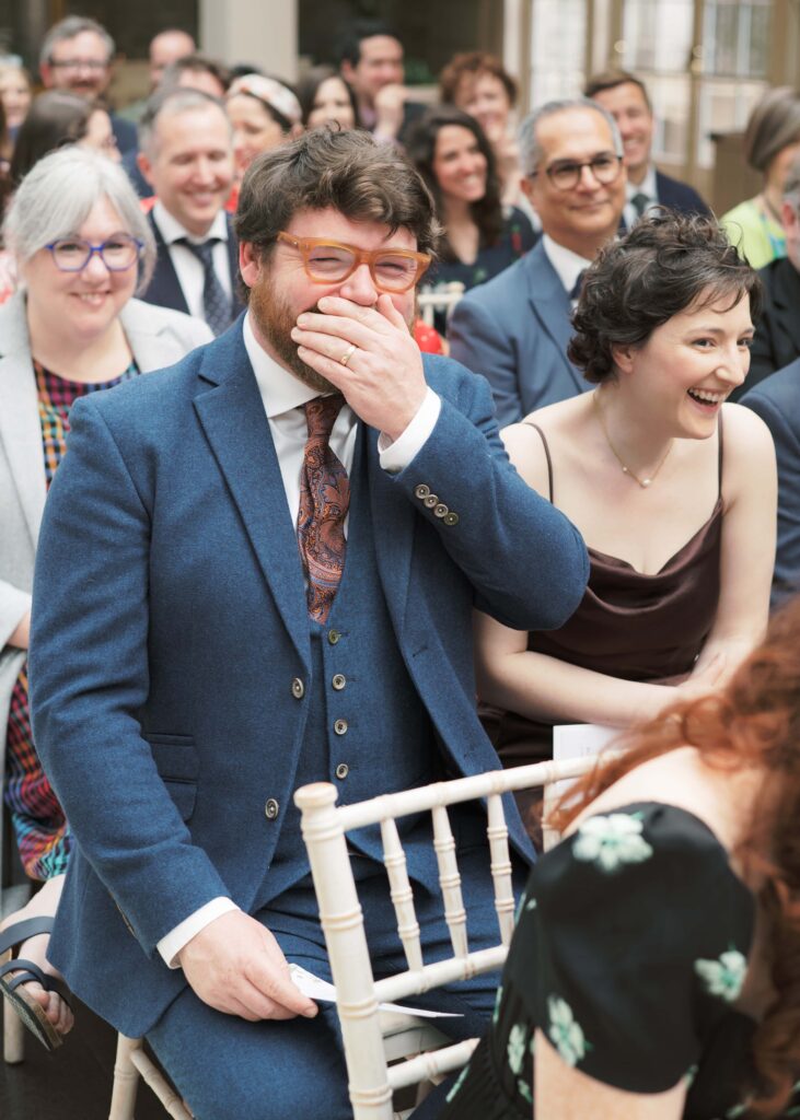 Wedding guests laugh with happiness during the ceremony.