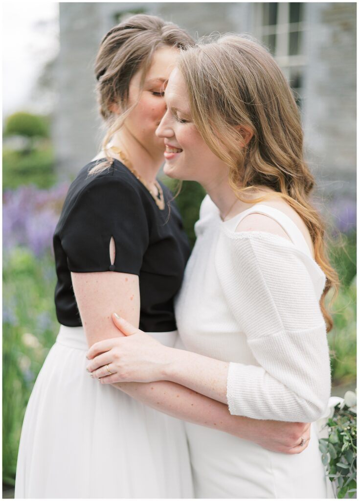 Same-sex wedding photography of couple embracing in the flowery entrance at Tankardstown House.