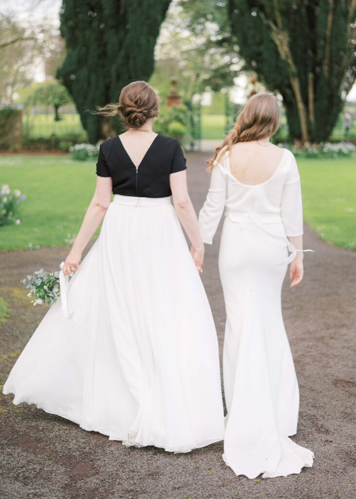 Two brides walk together in Tankardstown House's Walled Garden.