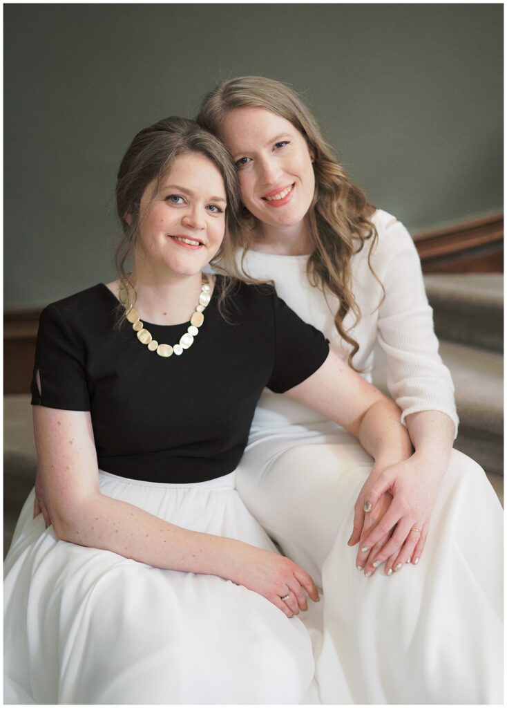 Posed same-sex couple portrait on the stairway inside Tankardstown House.