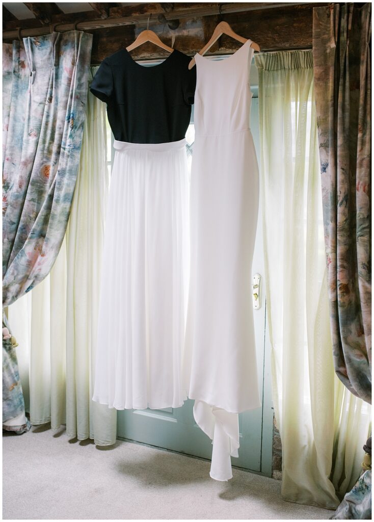 Bride's dresses hang together by the veiled window of the Secret Garden room.