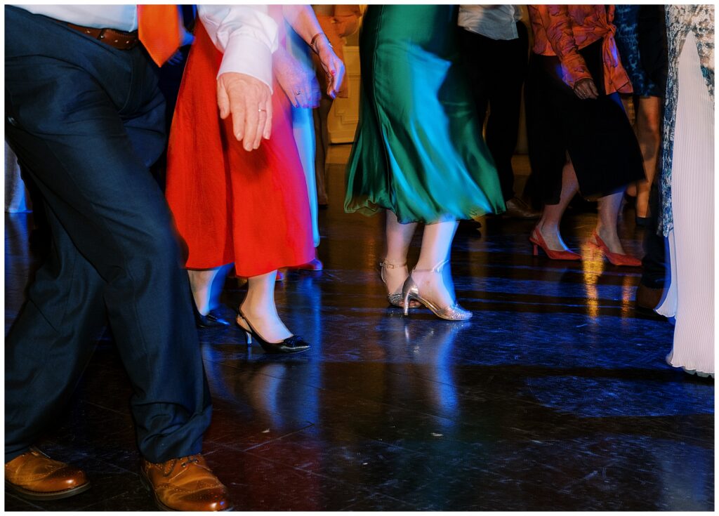 Low-angle photo of feet dancing across the dance floor with dramatic lighting and colours.