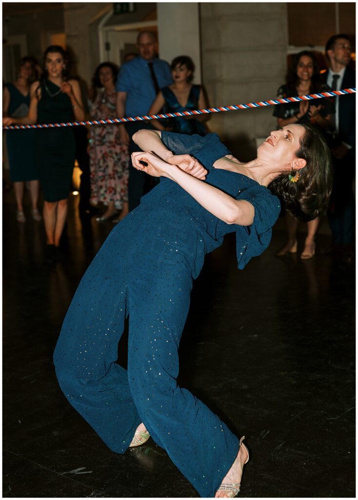 Wedding guest bends under the limbo rope on the dance floor.