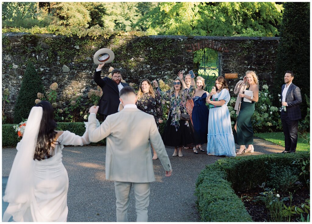 Bride and groom are greeted by cheering guests at the Walled Garden at Tankardstown.