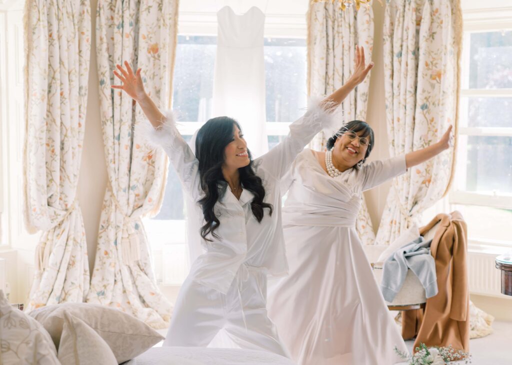 Bride and her mother dance happily on the morning of her autumn wedding.
