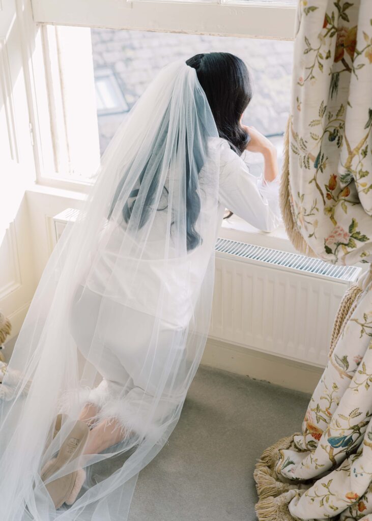Bride gazes out the window of the Master Suite onto the autumn scenery outside Tankardstown House.