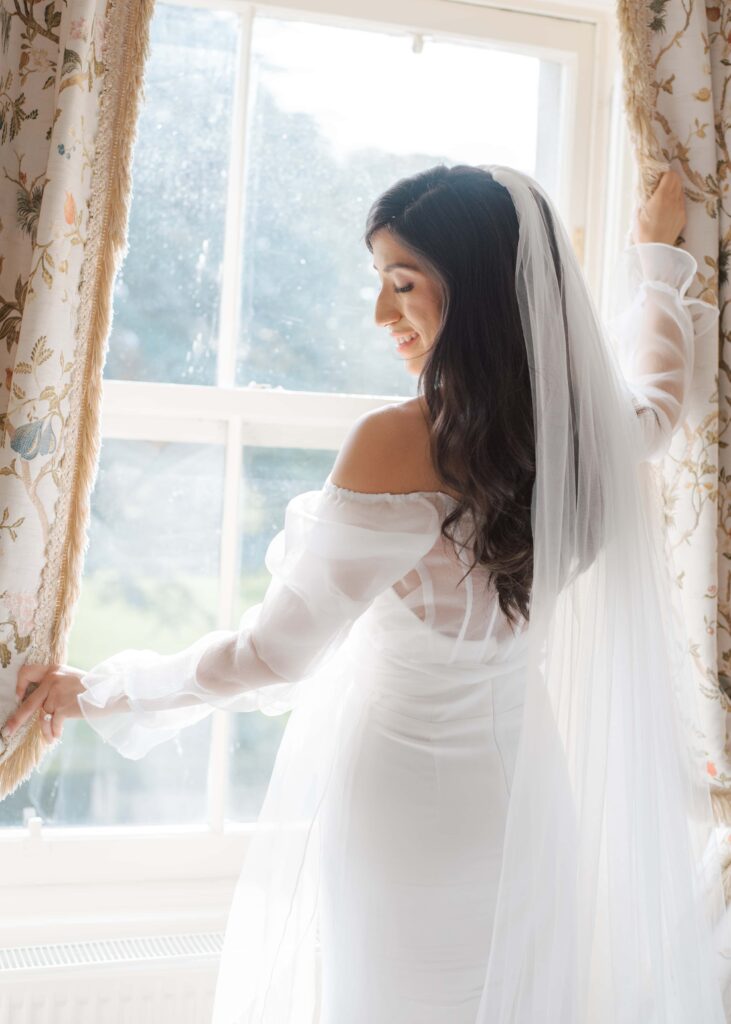 Close up portrait of the bride in her wedding dress at the window in Tankardstown House.