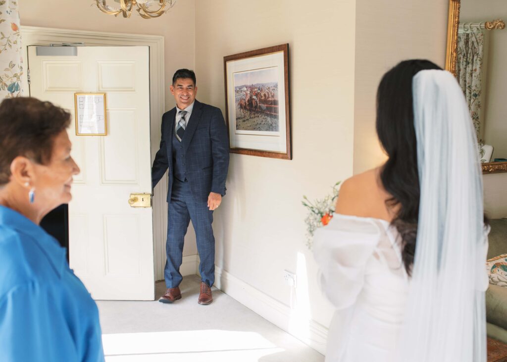 Bride's father arrives and first sees his daughter in her wedding dress.