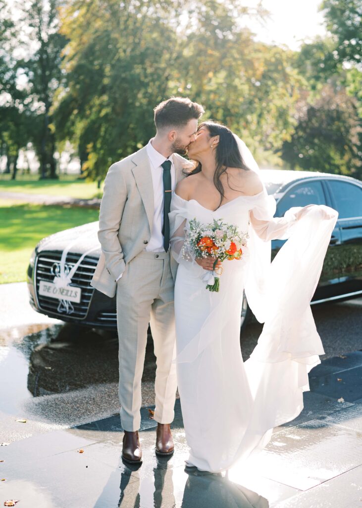 Husband and wife share a kiss in the gorgeous light of their autumn wedding day.