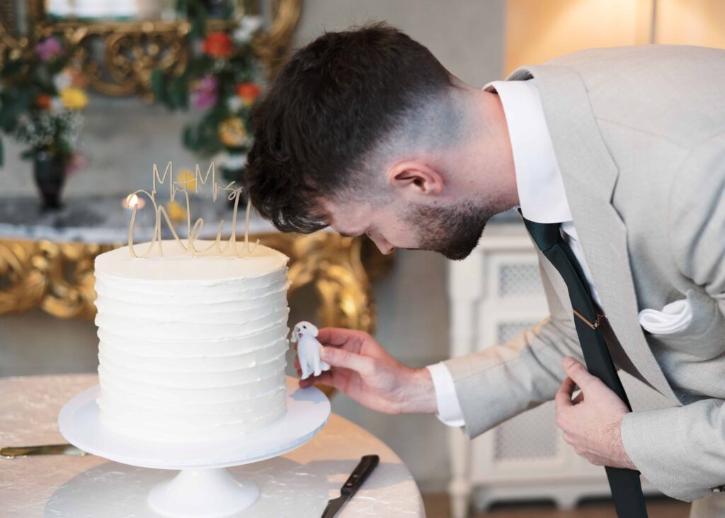Groom places a toy replica of his dog next to his wedding cake in Tankardstown House.