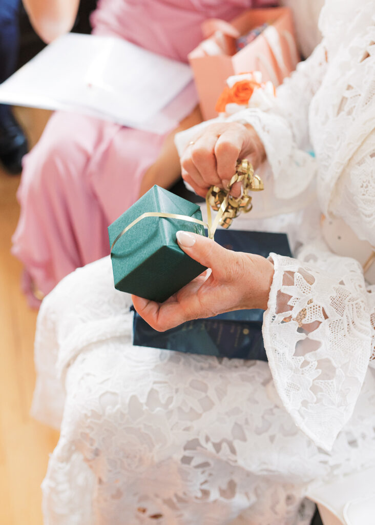 Close-up photo of the bride's mother opening her gift on the morning of her daughter's wedding.