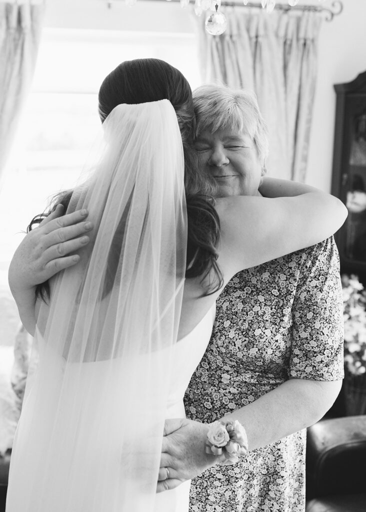 Bride hugs her mother.