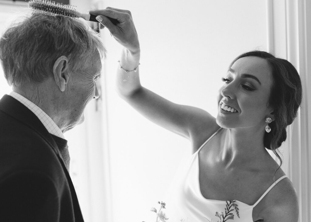 Bride comb's her grandfather's hair on the morning of her wedding.