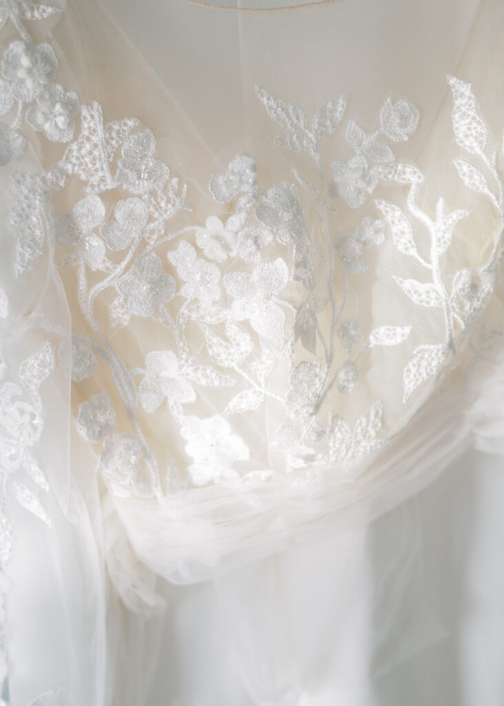 Detailed photo of the texture and pattern of the bride's wedding dress.