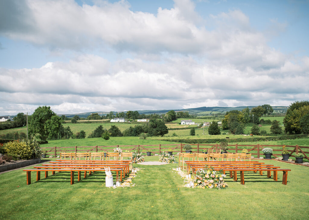 Garden Wedding ceremony location, with pews and flowers overlooking the countryside.