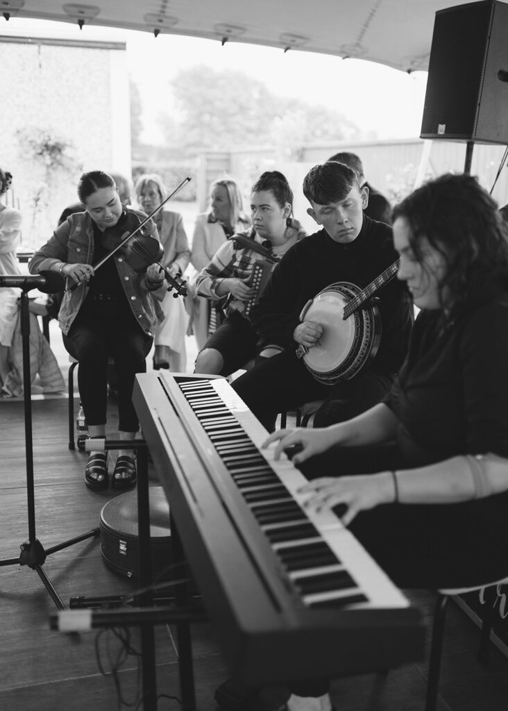 Traditional Irish ceili band play for wedding guests at this at home garden wedding.