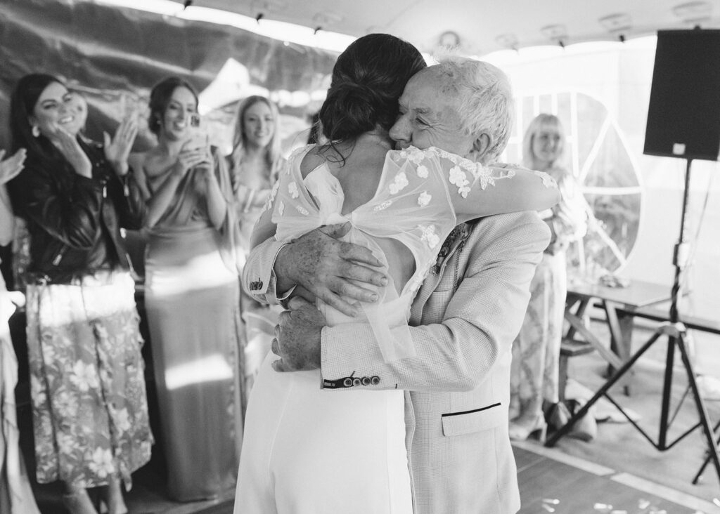Bride and her father share an emotional embrace on the evening of her home garden wedding.